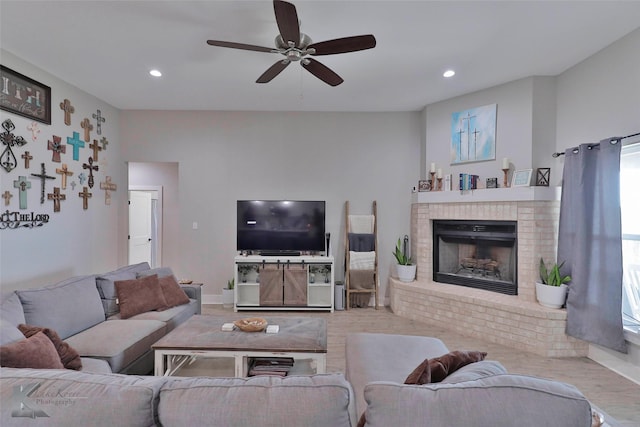 living room with ceiling fan and a brick fireplace