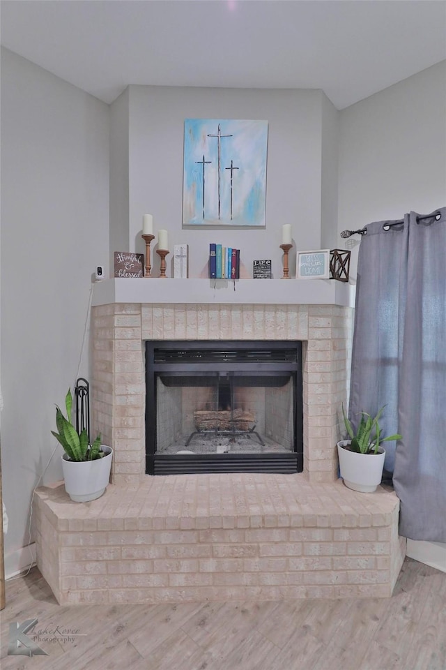 interior details with hardwood / wood-style flooring and a brick fireplace