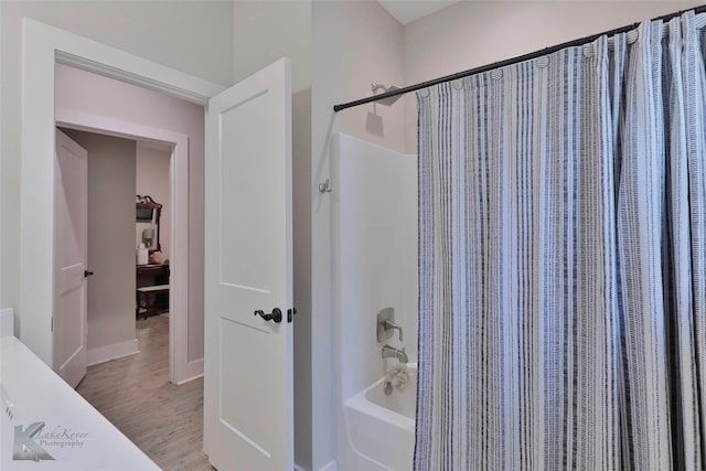 bathroom with hardwood / wood-style floors and shower / tub combo with curtain