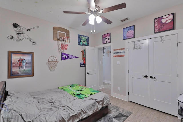 bedroom with ceiling fan, light wood-type flooring, and a closet