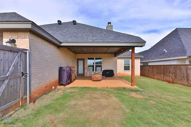 rear view of property with a yard and a patio area