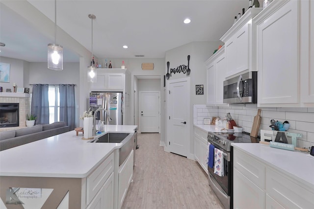 kitchen featuring tasteful backsplash, pendant lighting, white cabinets, and stainless steel appliances