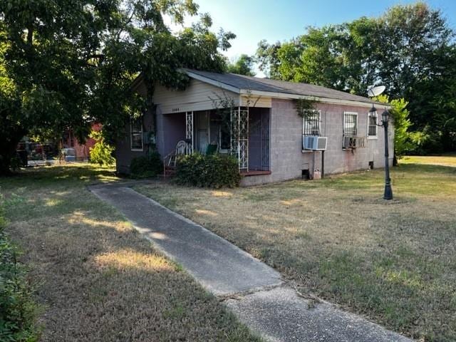 view of front facade featuring cooling unit and a front lawn