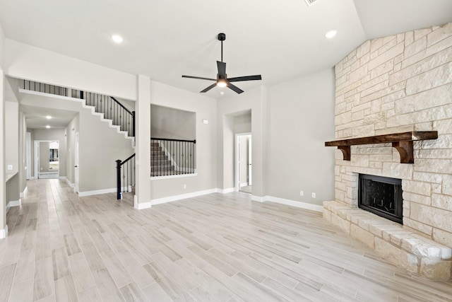 living room featuring a large fireplace, a healthy amount of sunlight, lofted ceiling, and hardwood / wood-style floors