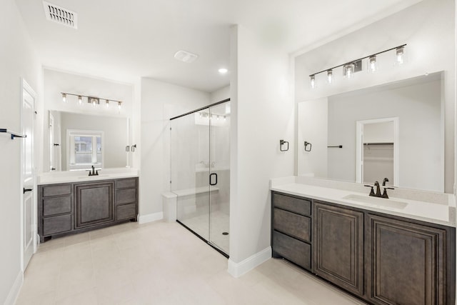 bathroom featuring tile patterned flooring, vanity, and a shower with door