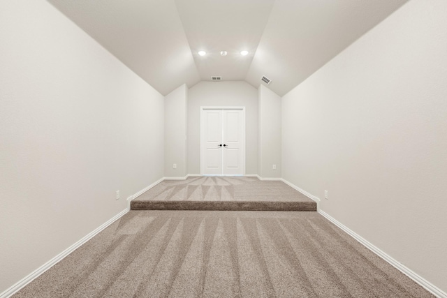 bonus room with carpet floors and vaulted ceiling