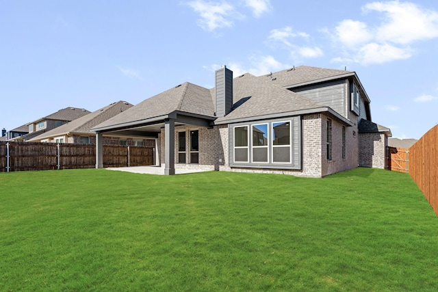 rear view of house with a yard and a patio