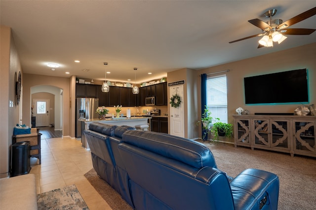 carpeted living room with a wealth of natural light and ceiling fan