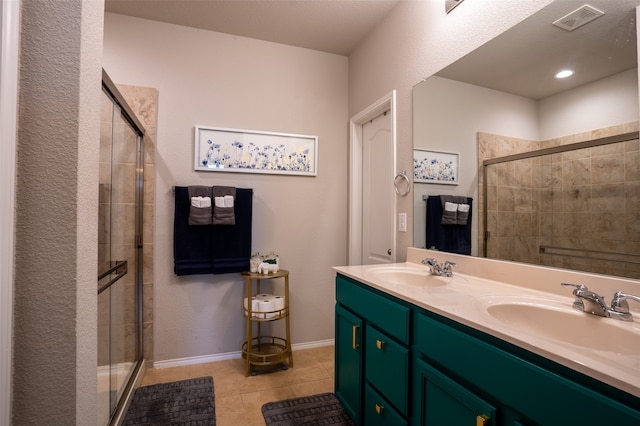 bathroom featuring a shower with door, tile patterned flooring, and double sink vanity