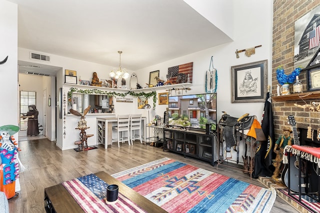 living room featuring a notable chandelier, a fireplace, and hardwood / wood-style flooring