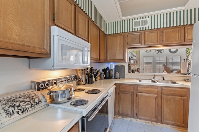 kitchen featuring white appliances, light tile patterned floors, ornamental molding, sink, and plenty of natural light