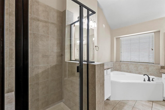 bathroom with tile patterned floors, shower with separate bathtub, and vaulted ceiling