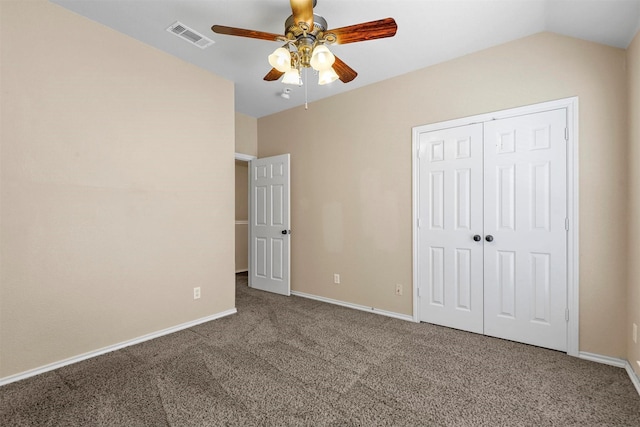 unfurnished bedroom featuring vaulted ceiling, a closet, ceiling fan, and carpet flooring