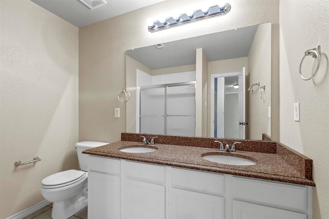 bathroom with vanity, tile patterned floors, toilet, and walk in shower