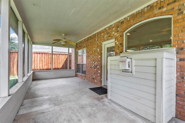 unfurnished sunroom with wood ceiling, ceiling fan, and a healthy amount of sunlight