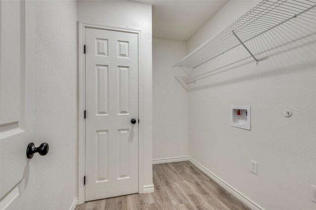 clothes washing area featuring washer hookup and light hardwood / wood-style flooring