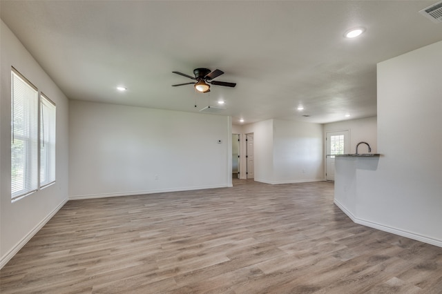 unfurnished living room featuring ceiling fan and light hardwood / wood-style floors