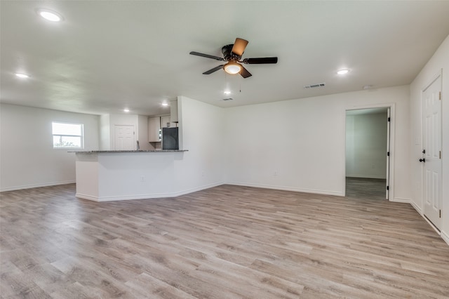 unfurnished living room with light wood-type flooring and ceiling fan