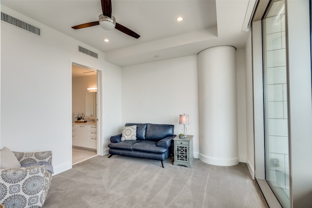 living area with ceiling fan and light colored carpet