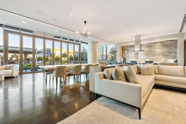 living room featuring expansive windows, wood-type flooring, and a chandelier