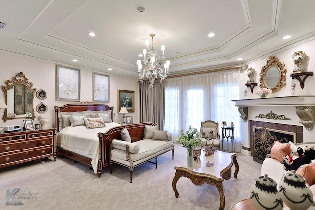 carpeted bedroom with a chandelier, a premium fireplace, and a tray ceiling