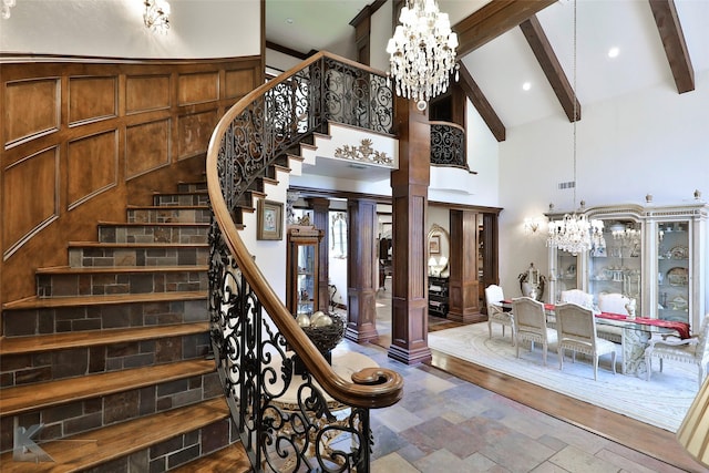 stairway featuring decorative columns, beamed ceiling, high vaulted ceiling, and a notable chandelier