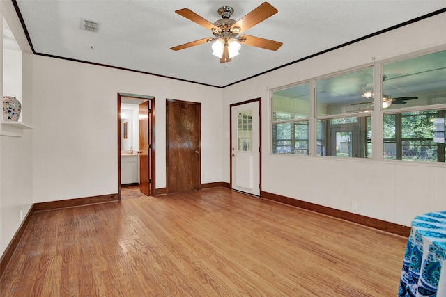 spare room with light hardwood / wood-style floors, a textured ceiling, ceiling fan, and ornamental molding