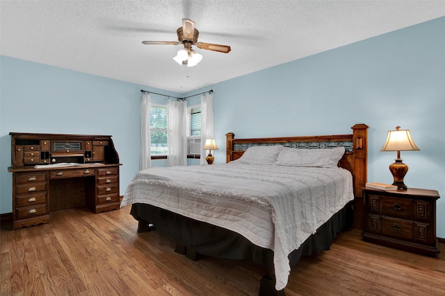 bedroom featuring ceiling fan, a textured ceiling, and light wood-type flooring