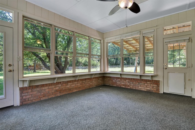 unfurnished sunroom featuring ceiling fan and a wealth of natural light