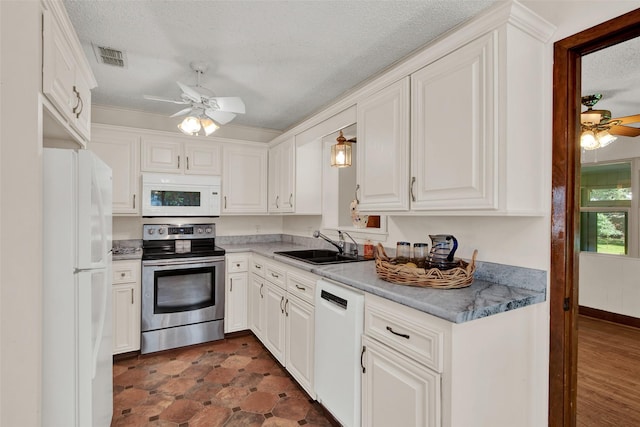 kitchen with white cabinetry, sink, white appliances, and a textured ceiling