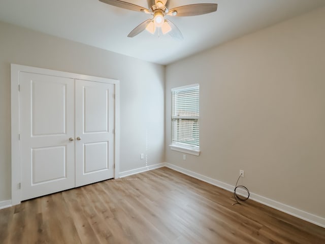 unfurnished bedroom featuring ceiling fan, a closet, and light hardwood / wood-style flooring