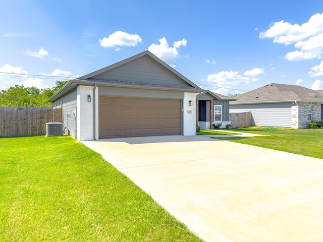 ranch-style home featuring a garage, a front lawn, and central air condition unit