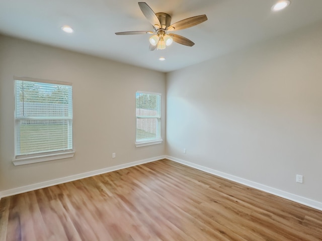 spare room featuring light wood-type flooring, a wealth of natural light, and ceiling fan