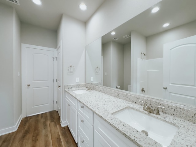 bathroom featuring a shower, toilet, vanity, and hardwood / wood-style flooring