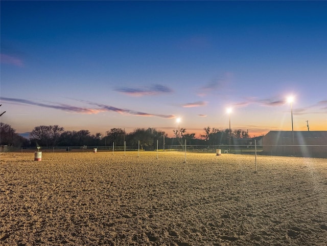 yard at dusk featuring a rural view