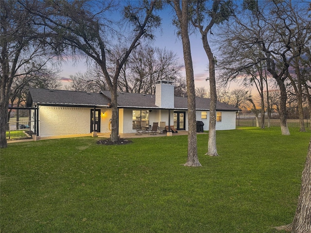 view of front of home featuring a lawn and a patio