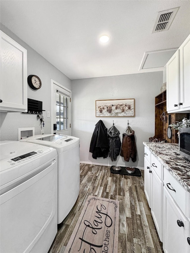 laundry room with cabinets, washer and dryer, and dark hardwood / wood-style floors