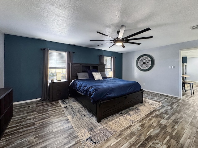 bedroom featuring a textured ceiling, ceiling fan, and dark wood-type flooring