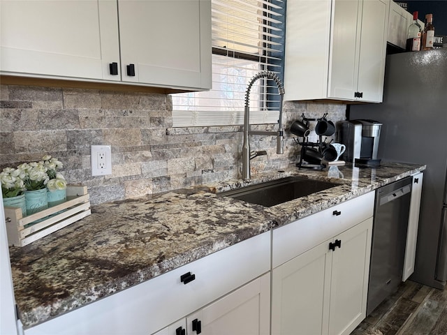 kitchen with dishwasher, sink, white cabinets, and dark stone countertops