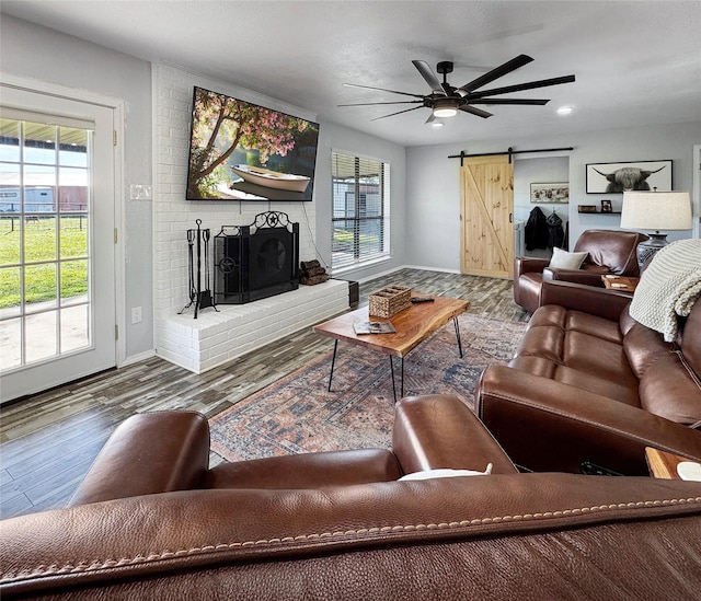 living room featuring a barn door, ceiling fan, and hardwood / wood-style floors