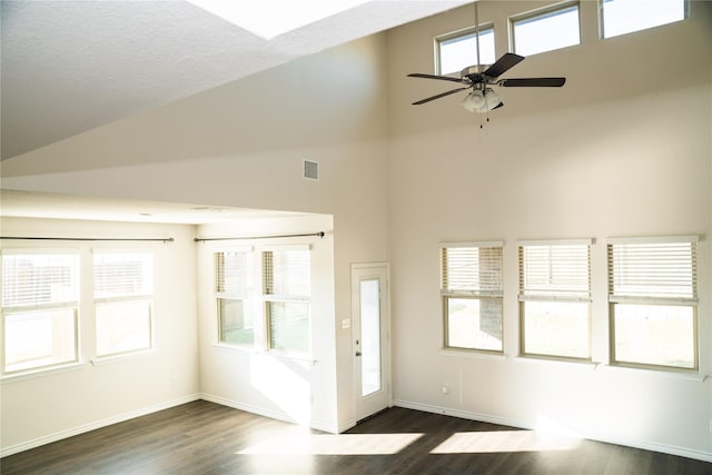 interior space with ceiling fan, a wealth of natural light, high vaulted ceiling, and dark hardwood / wood-style floors