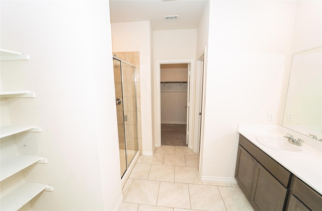 bathroom featuring vanity, tile patterned floors, and a shower with door