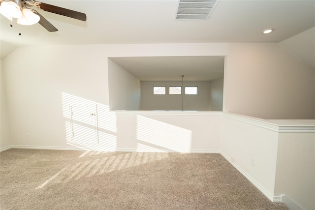 spare room featuring ceiling fan, carpet flooring, and vaulted ceiling