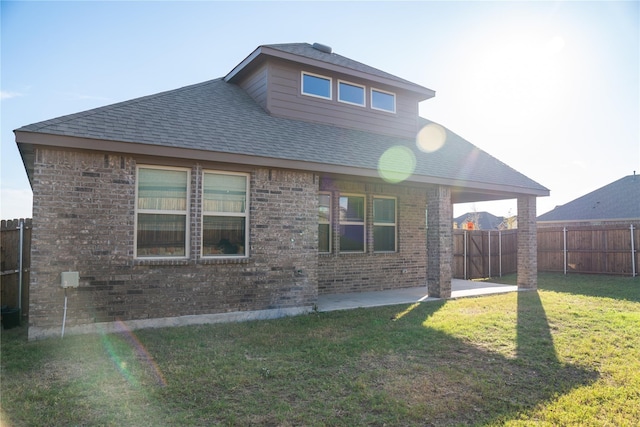 rear view of property featuring a patio area and a yard