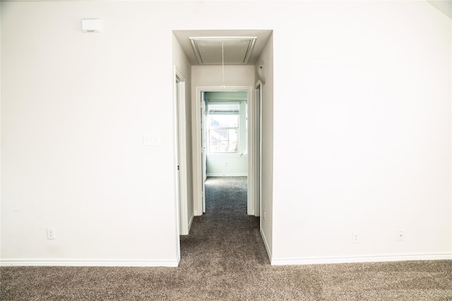 hallway with dark colored carpet