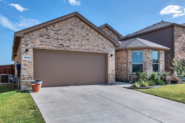 view of front of home featuring concrete driveway, an attached garage, a front lawn, central AC, and brick siding