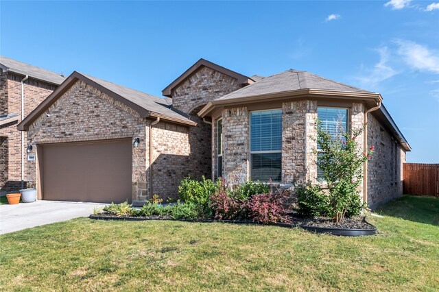 view of front of home featuring a front yard, concrete driveway, brick siding, and a garage