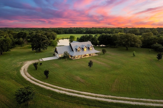 aerial view at dusk with a rural view and a water view