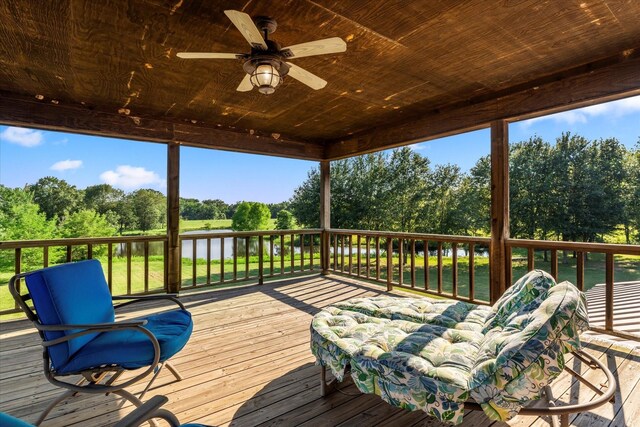 wooden terrace featuring ceiling fan and a water view