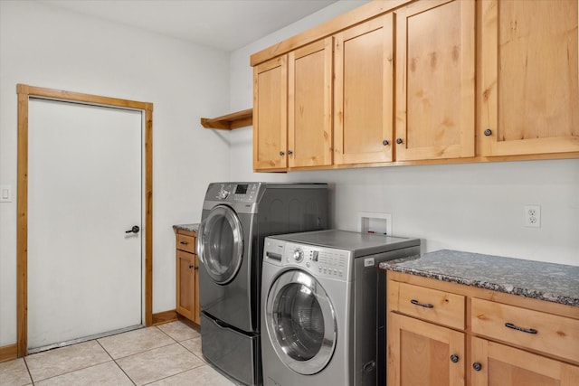 washroom featuring cabinets, light tile patterned flooring, and washing machine and clothes dryer